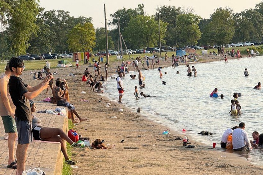 A crowded beach with people swimming and relaxing on the sand. 5