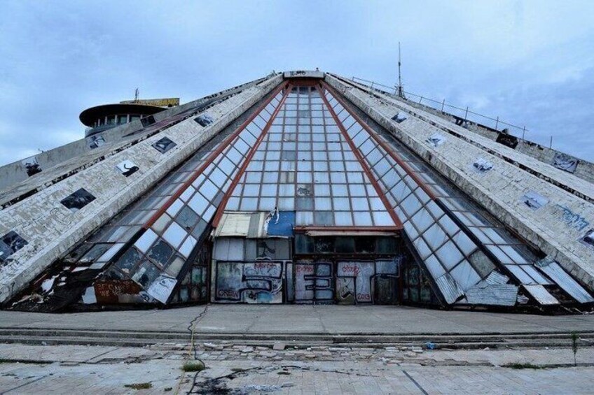 A large, triangular building with a glass facade and graffiti. 3