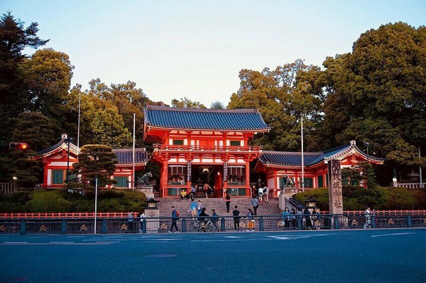 A traditional Japanese building with a red roof and white walls, surrounded by trees and a blue sky. 3