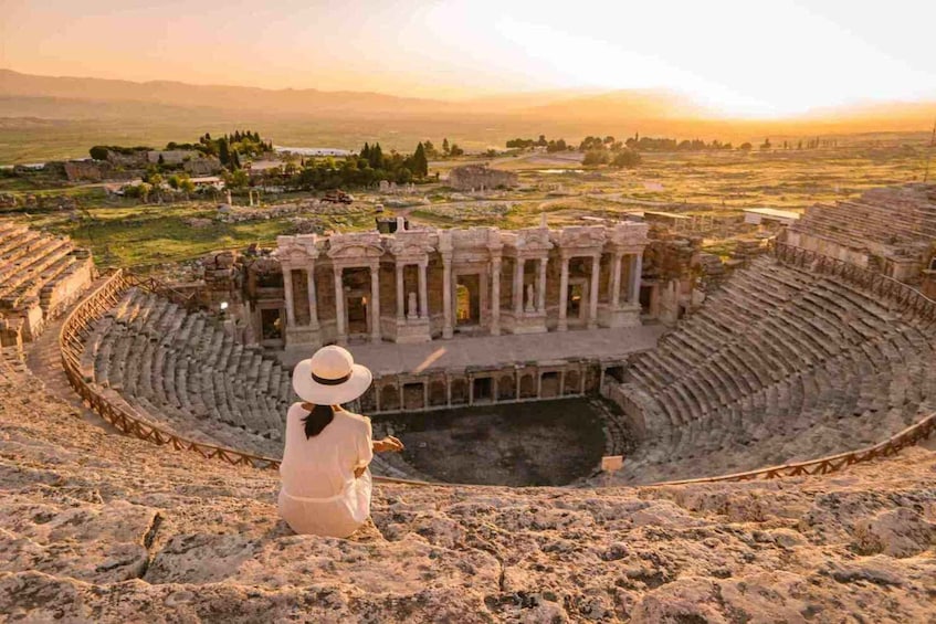 An ancient amphitheater with ruins and a person in the foreground. 4