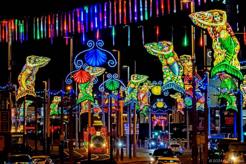 A street decorated with colorful, illuminated mermaid sculptures. 3