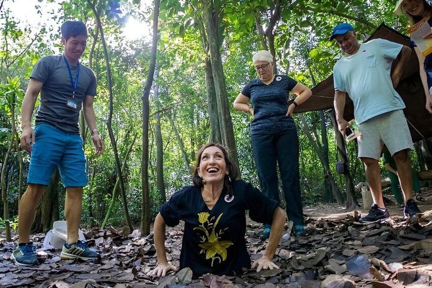 A group of people in a forested area with trees and a leaf-covered ground. 2
