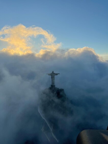 The Christ the Redeemer statue atop a mountain, surrounded by clouds. 5