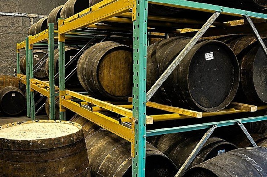 A warehouse with shelves stacked with wooden barrels. 5