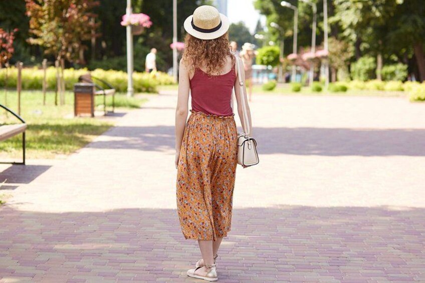 A person walking on a paved path in a park. 3