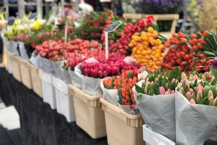 A flower market with various colorful flowers in bags. 4