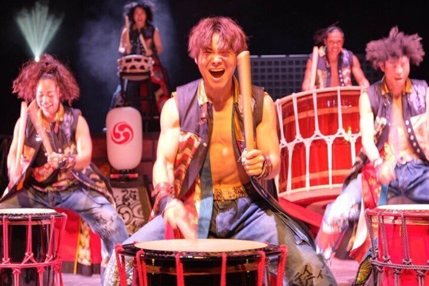 A group of people performing on stage with musical instruments. 2