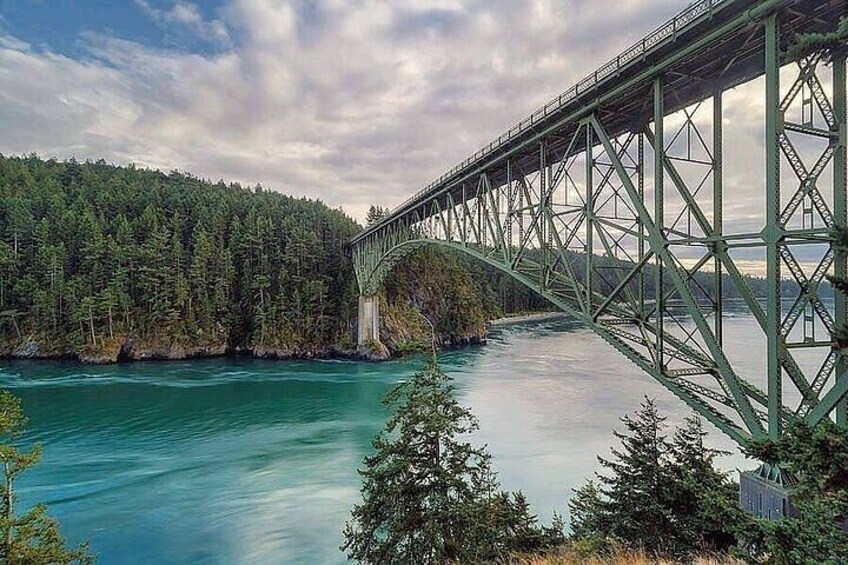 A steel bridge over a river with forested banks. 2