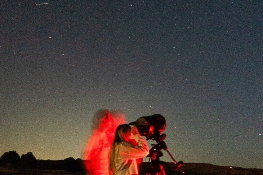 A person using a telescope to observe the night sky. 3