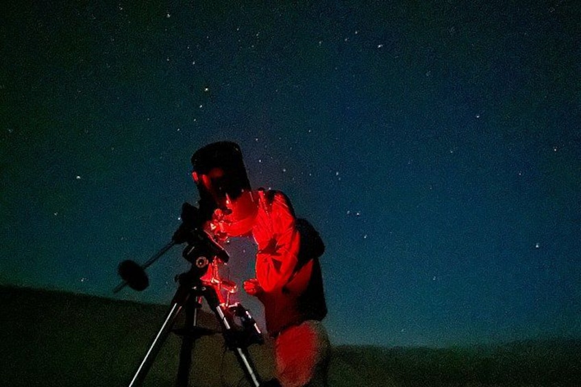 A person using a telescope under a starry night sky. 4