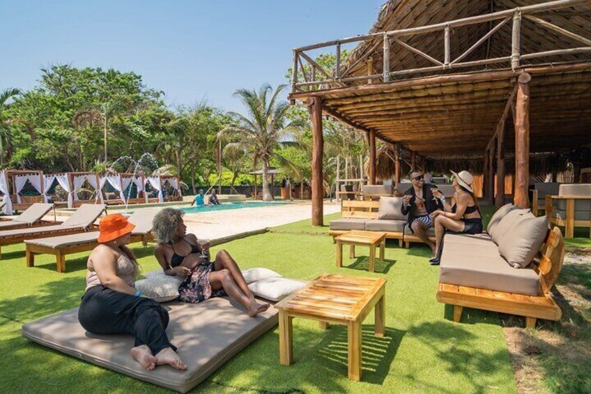 A tropical resort with outdoor seating, a pool, and lush greenery. 2