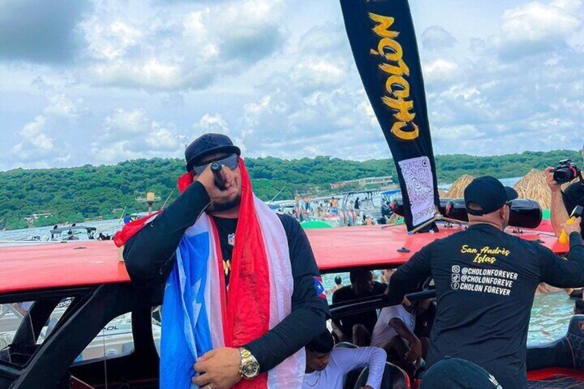 A boat with a flag, a person in a black cap, and a person in a black shirt with text on the back. 3