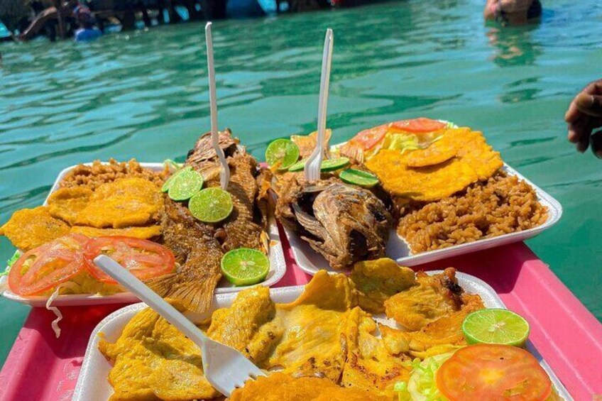 A variety of grilled seafood and plantains on a boat with a body of water in the background. 5