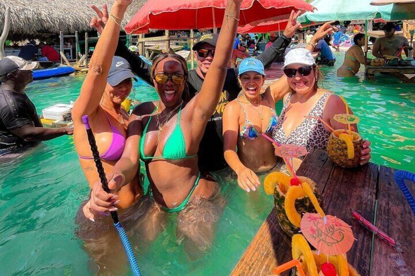 People in a pool with drinks and umbrellas. 4