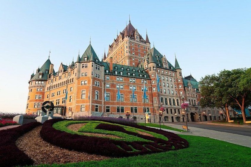 A large, historic building with multiple towers and a well-maintained garden. 1