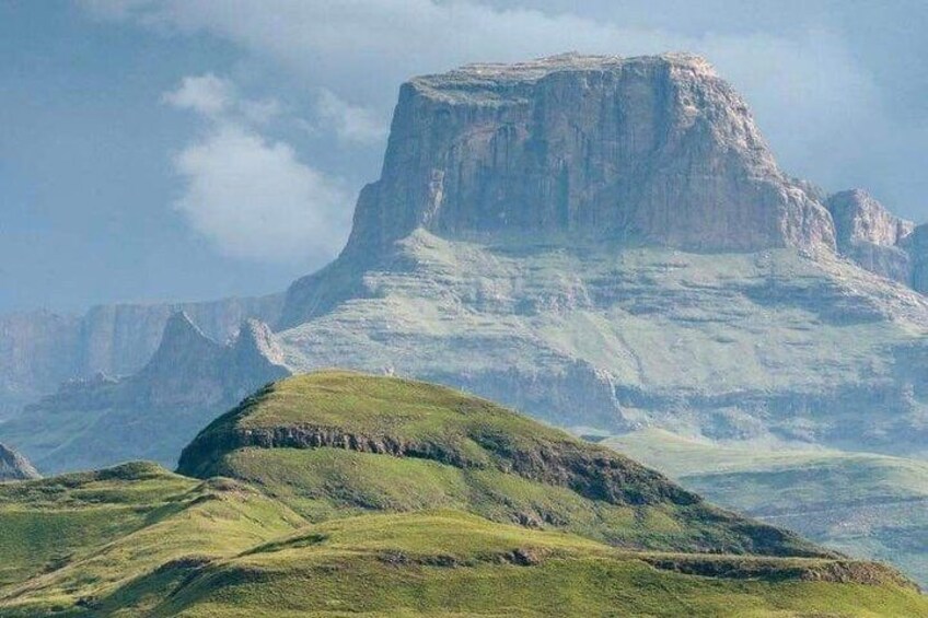 A mountain landscape with a prominent peak and rolling green hills. 3