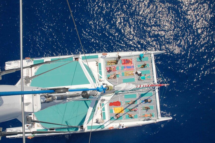 A sailboat with a deck area, including a seating area with sun loungers and a flag. 4