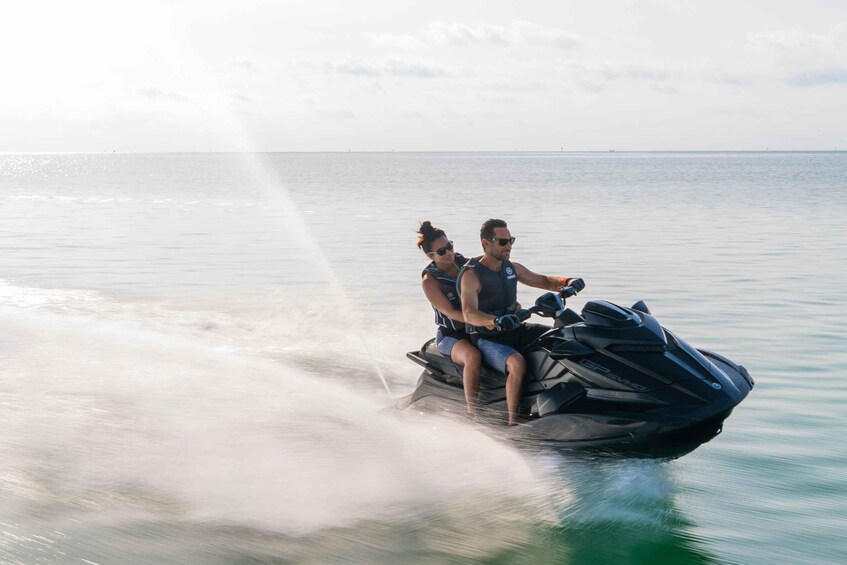 Two people on a jet ski in calm water. 2