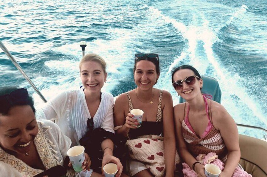 Three people on a boat with a wake behind them. 2