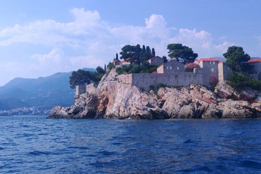 A coastal fortress with red-roofed buildings on a rocky outcrop. 4