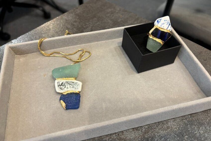 A jewelry display with a ring and a pendant on a tray. 3