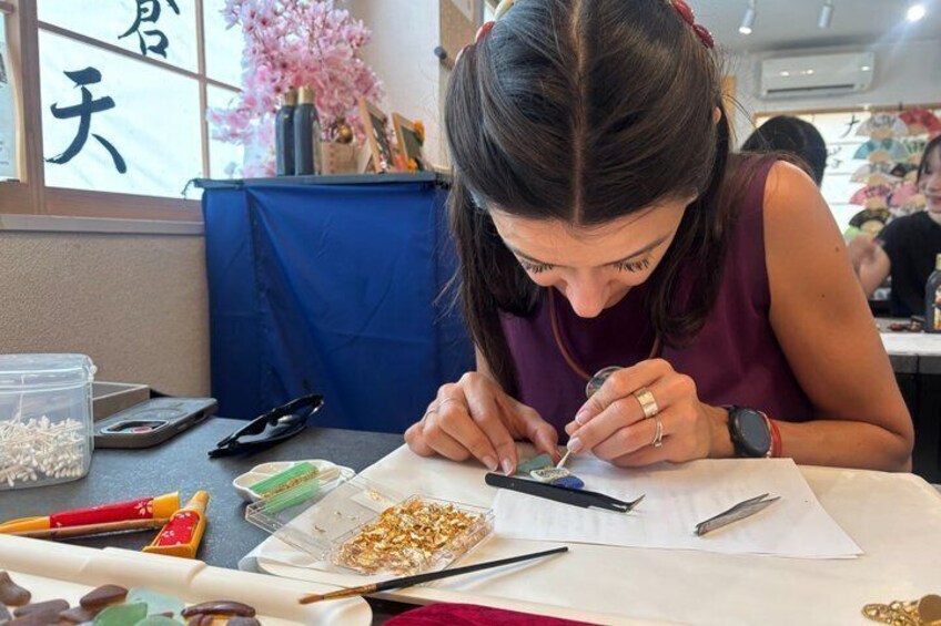A person drawing at a table with art supplies. 2