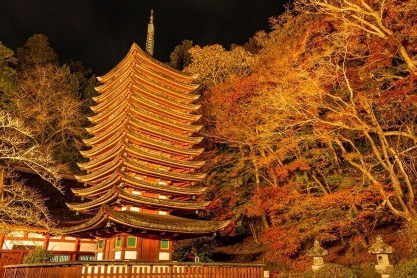 A traditional Japanese pagoda with multiple tiers, surrounded by autumn-colored trees. 1