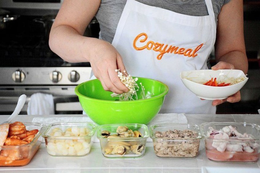 A person preparing food with various ingredients in bowls and containers. 1