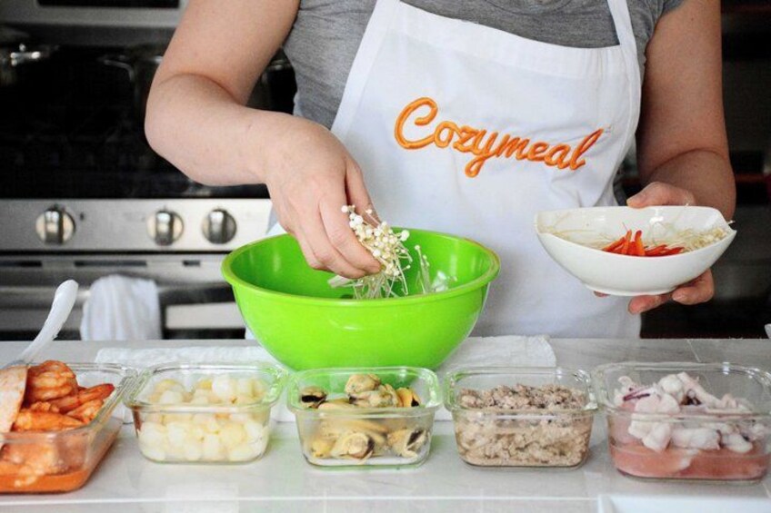 A person preparing food with various ingredients in bowls and containers. 1