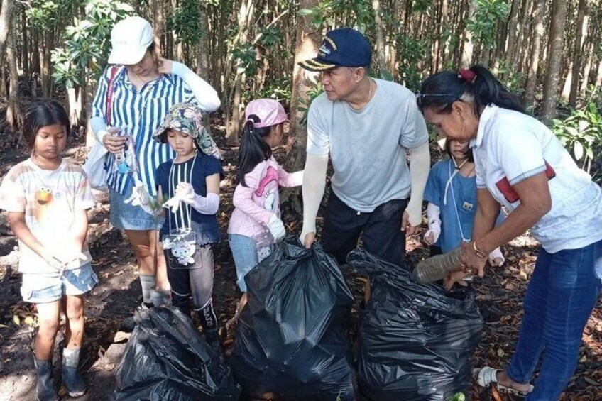 A group of people collecting trash in a forested area. 5