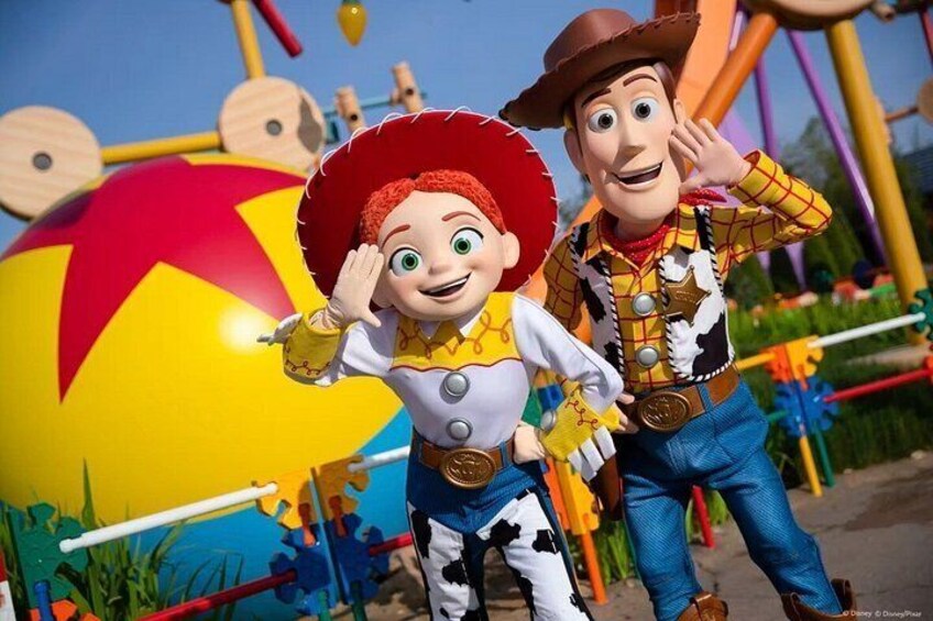 Two characters standing in front of a large, colorful beach ball and a playground structure. 2
