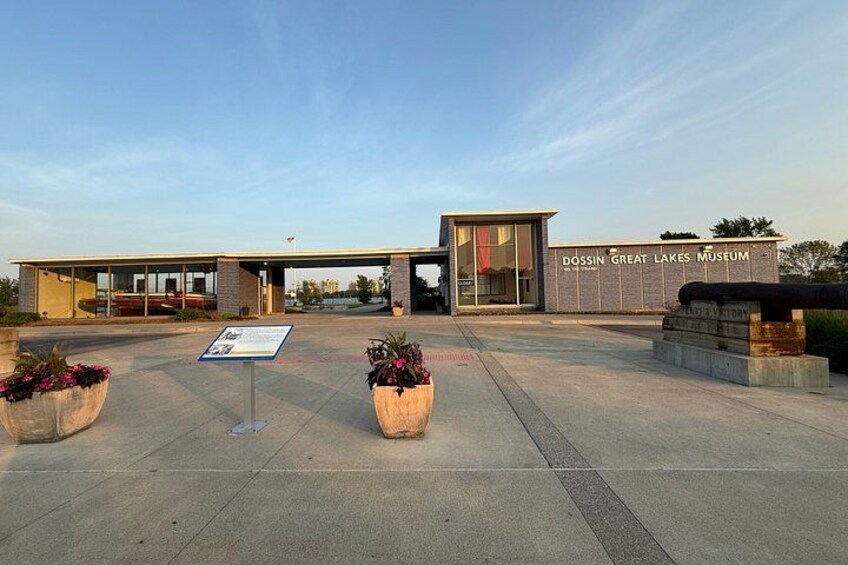 The Dossin Great Lakes Museum with a modern architectural design, featuring a large glass entrance and a signboard. 2