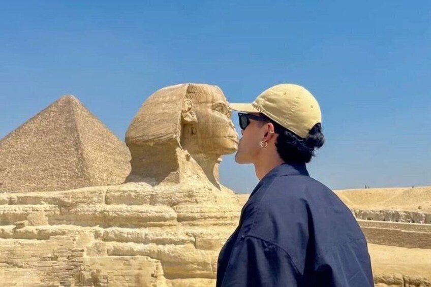 A person standing in front of the Great Sphinx and the Pyramid of Khafra. 5