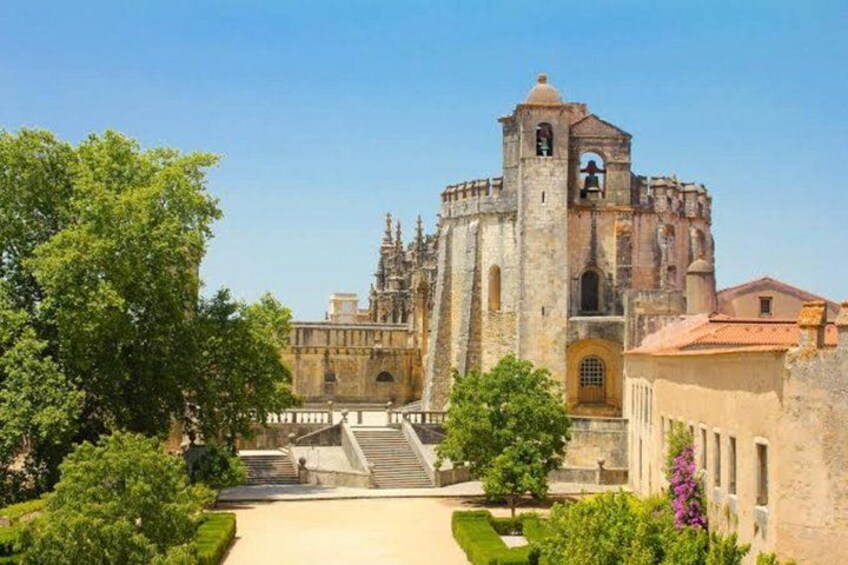 A historic church with a bell tower, surrounded by greenery and a clear sky. 1