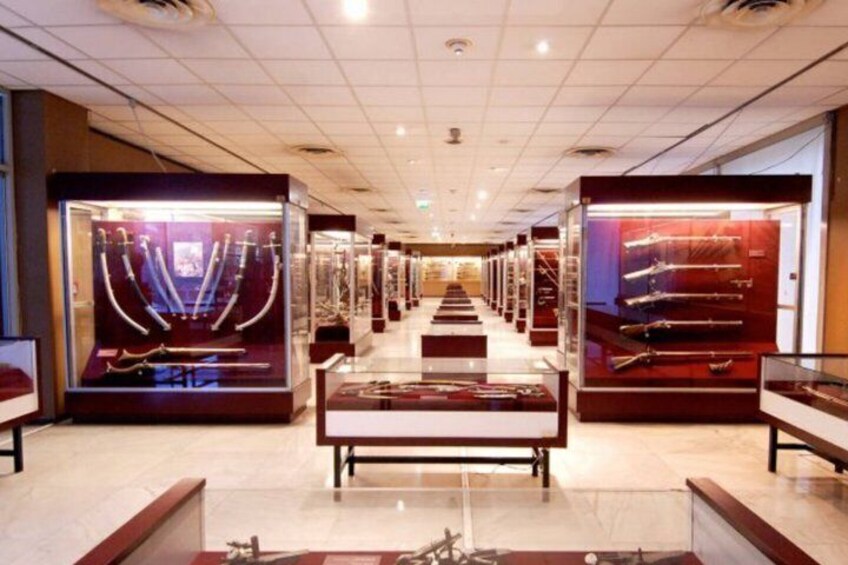 A museum interior with glass display cases and a central walkway. 3
