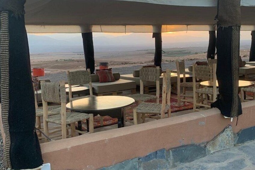 An outdoor seating area with tables and chairs, overlooking a desert landscape. 4