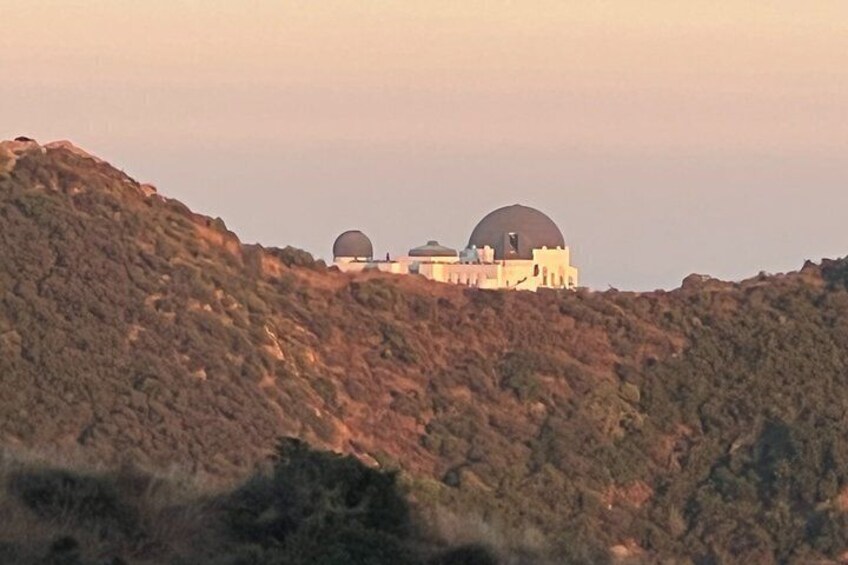 A mountainous landscape with a building featuring two large domes. 5