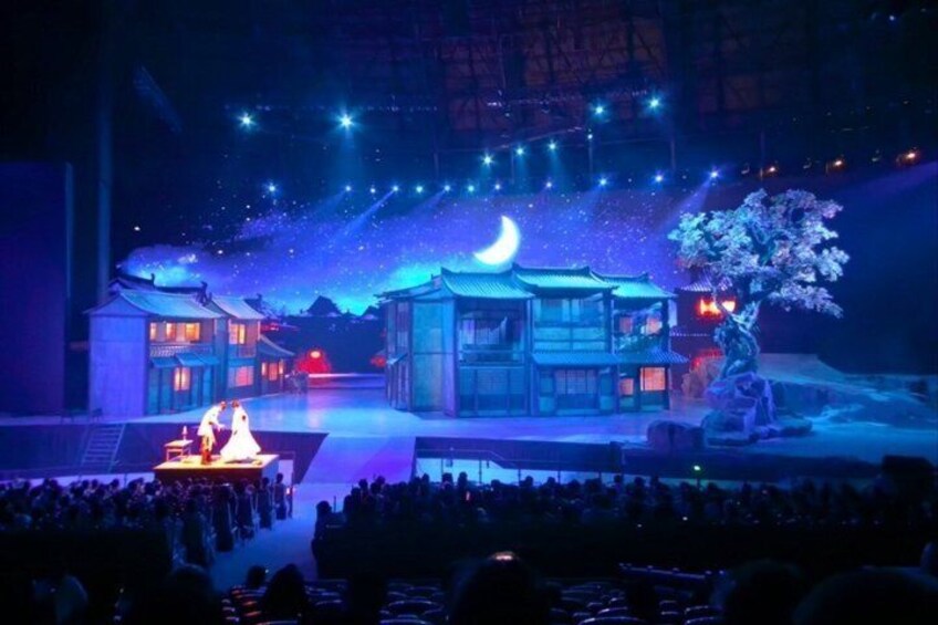 A stage with traditional buildings, a tree, and a crescent moon. 2