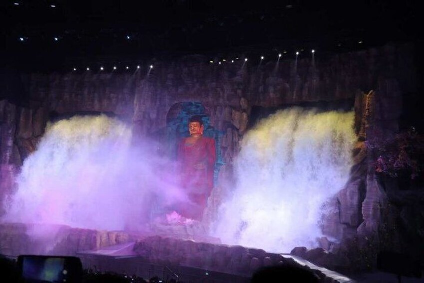 A person standing in front of a waterfall with water spraying around them. 5