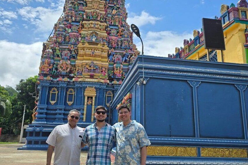 A colorful temple with intricate carvings and a blue structure in the foreground. 4