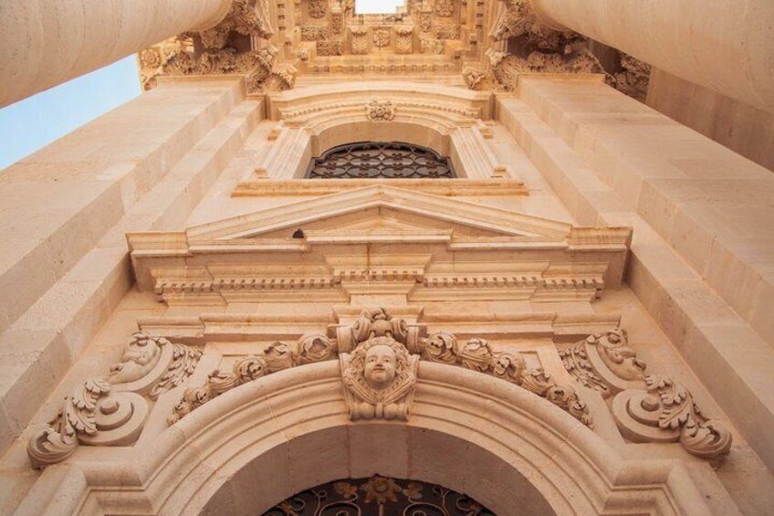 A detailed architectural structure with ornate carvings and a central archway. 4