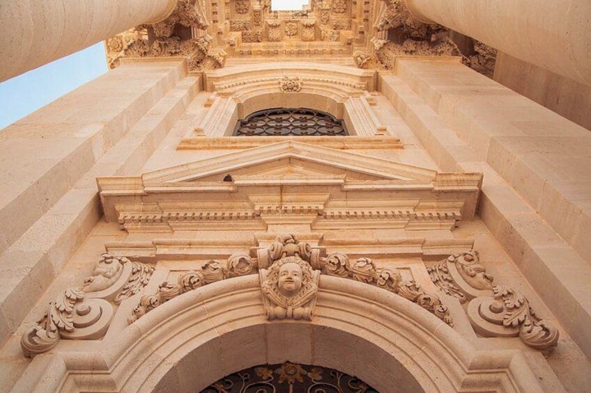 A detailed architectural structure with ornate carvings and a central archway. 3