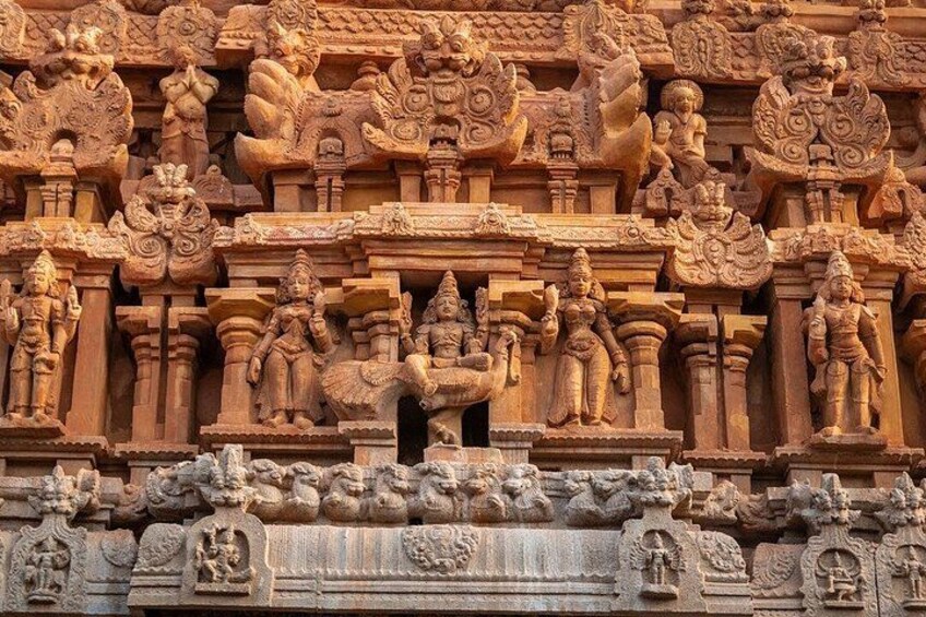 Detailed stone carvings of deities and mythological figures on a temple wall. 4