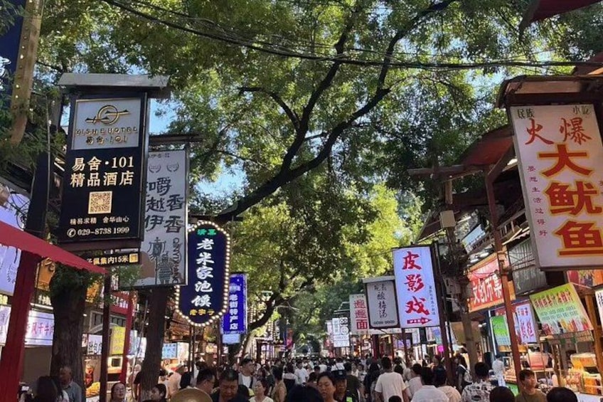 A crowded street lined with traditional Asian shops and signs. 3