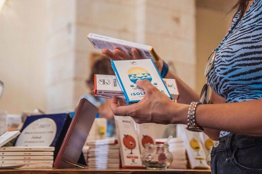 A person holding a book titled 'SOLON' at a table with other books and a glass. 2