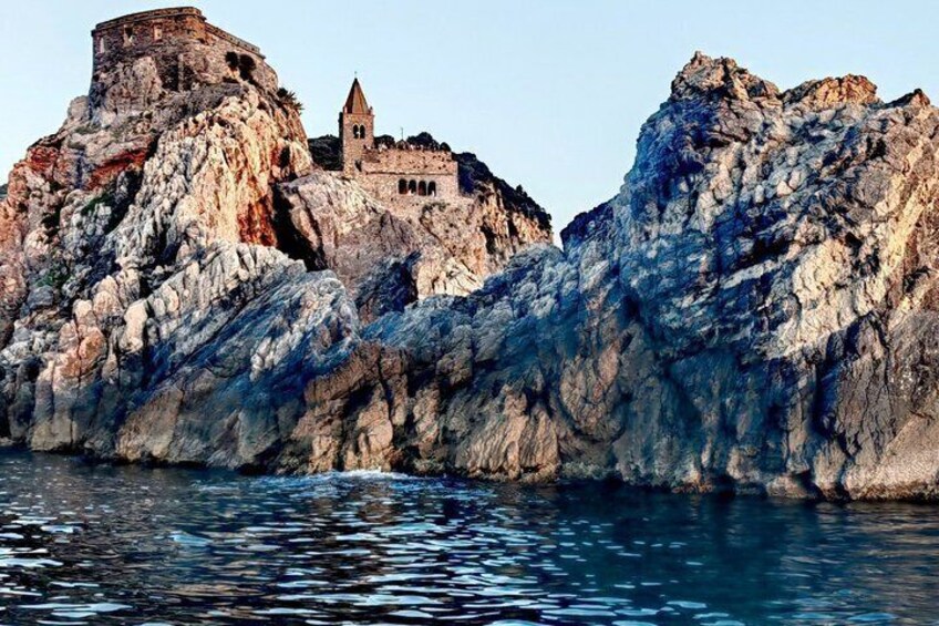 A rocky coastline with a historic building perched atop a cliff. 4