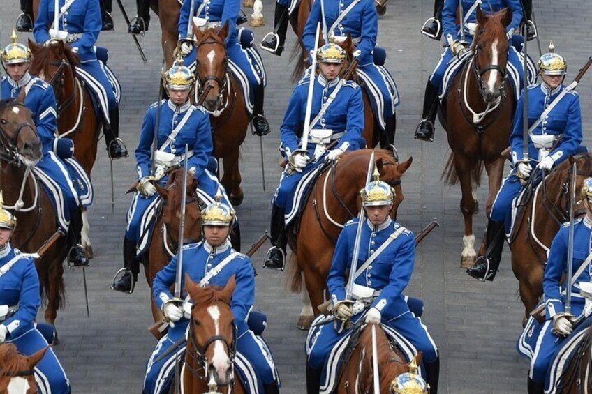 Un groupe de gardes vêtus d’uniformes bleus, à cheval, qui se déplace en formation. 3
