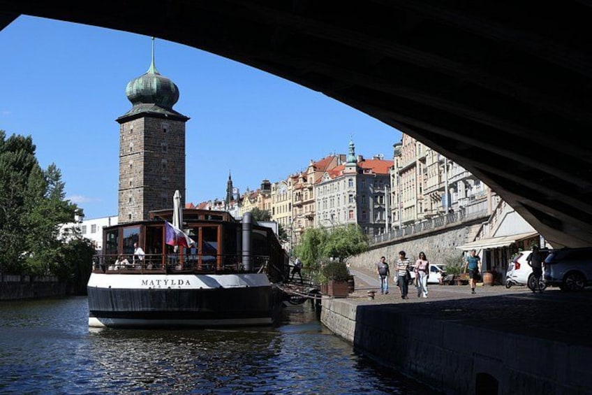 A boat named MATYLDA on a river, a tower, and a bridge. 2