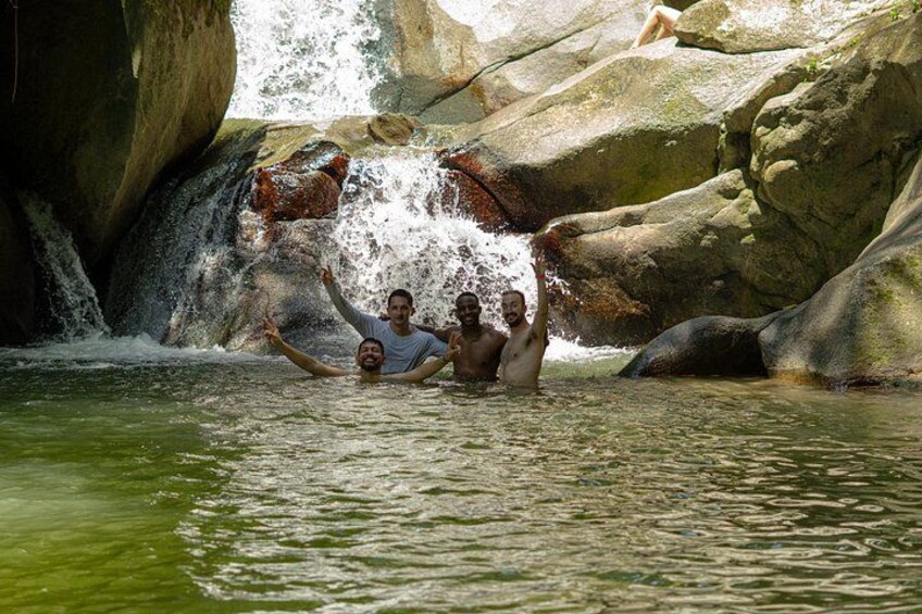 A waterfall, rocky terrain, and people in a natural setting. 5