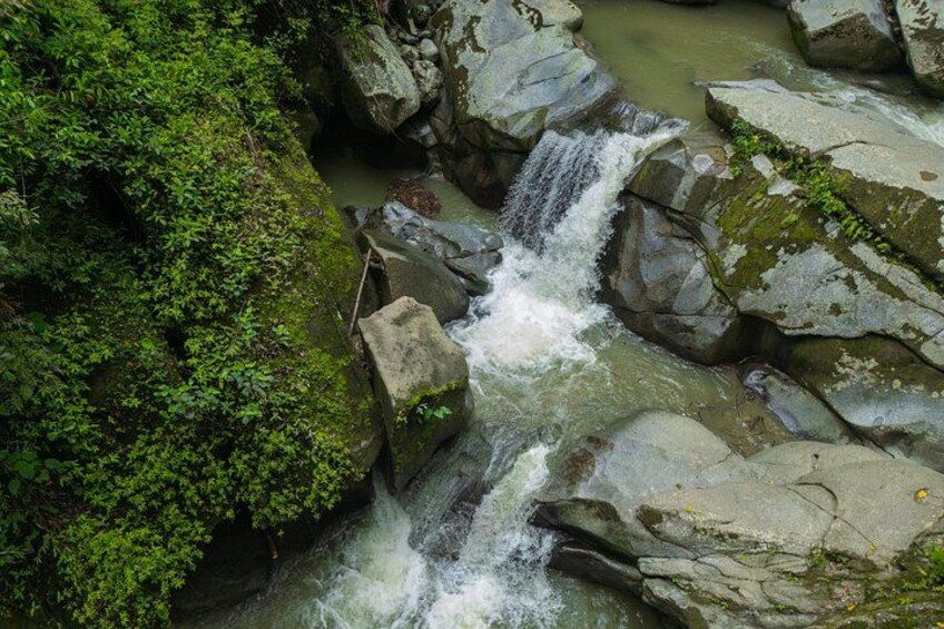 A waterfall flowing over rocks in a forested area. 4